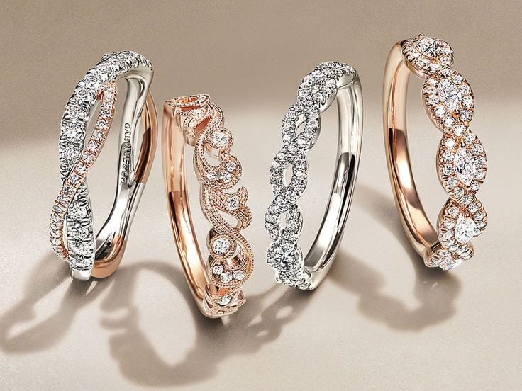 Two pairs of wedding rings of different colors, one pair of gold wedding bands and one pair of platinum wedding bands